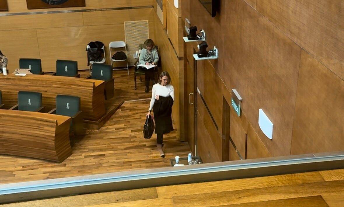 Imagen de los asientos de Vox en el pleno del Ayuntamiento de València vacíos tras abandonar sus ediles la sesión y de una de las representantes de este partido saliendo de la sala. Foto: COMPROMÍS